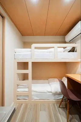 a room with two bunk beds and a desk at SAIE Skyview hotel in Tokyo
