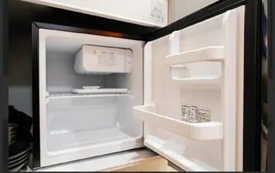 an empty refrigerator with its door open in a kitchen at SAIE Skyview hotel in Tokyo