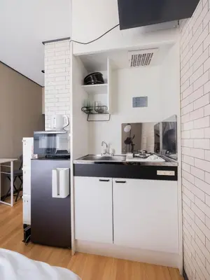a small kitchen with white cabinets and a sink at Better Than Outside 12 min Shibuya by train in Tokyo
