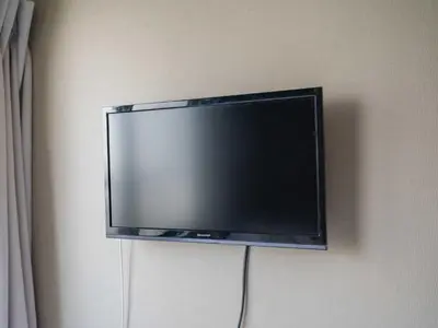 a flat screen tv hanging on a wall at Better Than Outside 12 min Shibuya by train in Tokyo