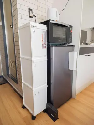 a white cabinet with a microwave and a refrigerator at Better Than Outside 12 min Shibuya by train in Tokyo