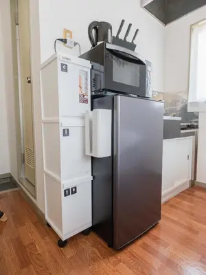 a refrigerator with a microwave on top of it at Better Than Outside 12 min Shibuya by train in Tokyo