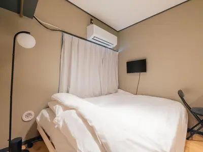a bedroom with a white bed and a window at Better Than Outside 12 min Shibuya by train in Tokyo