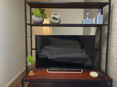 a television on a wooden table with a shelf at Yoi-Machi Heiwajima in Tokyo