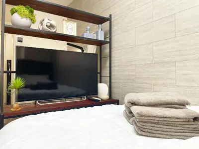 a bedroom with a flat screen tv and a bed at Yoi-Machi Heiwajima in Tokyo