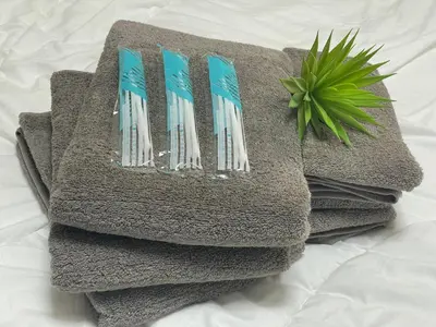 a pile of towels on a bed with a plant at Yoi-Machi Heiwajima in Tokyo