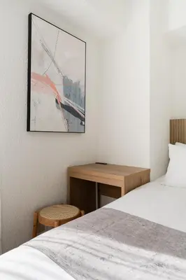 a bedroom with a bed and a wooden desk at Second Home SHINJUKU in Tokyo