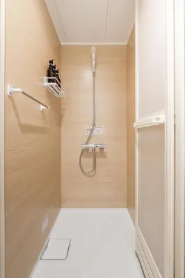 a shower in a bathroom with wooden walls at Second Home SHINJUKU in Tokyo