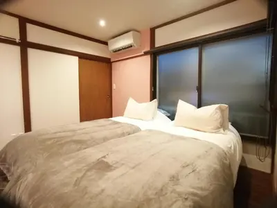 a bedroom with a large white bed with a window at \u53e4\u6c11\u5bb6\u9db4101\u5ba4 Tokyo\u65b0\u5bbf\u5730\u4e0b\u9244\u4e38\u306e\u5185\u7dda7\u5206 in Tokyo