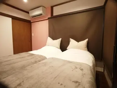 two beds sitting next to each other in a room at \u53e4\u6c11\u5bb6\u9db4101\u5ba4 Tokyo\u65b0\u5bbf\u5730\u4e0b\u9244\u4e38\u306e\u5185\u7dda7\u5206 in Tokyo
