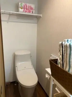 a bathroom with a toilet and a towel on a shelf at \u53e4\u6c11\u5bb6\u9db4101\u5ba4 Tokyo\u65b0\u5bbf\u5730\u4e0b\u9244\u4e38\u306e\u5185\u7dda7\u5206 in Tokyo