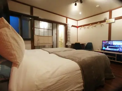 a bedroom with a large bed and a television at \u53e4\u6c11\u5bb6\u9db4101\u5ba4 Tokyo\u65b0\u5bbf\u5730\u4e0b\u9244\u4e38\u306e\u5185\u7dda7\u5206 in Tokyo