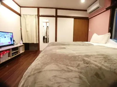 a hotel room with a large bed and a tv at \u53e4\u6c11\u5bb6\u9db4101\u5ba4 Tokyo\u65b0\u5bbf\u5730\u4e0b\u9244\u4e38\u306e\u5185\u7dda7\u5206 in Tokyo