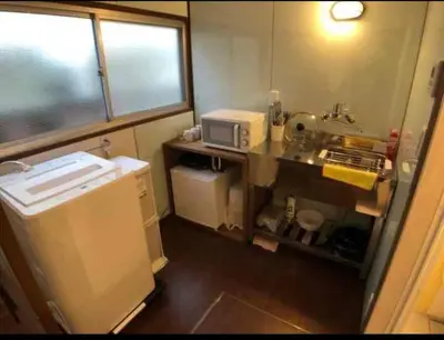 a small kitchen with a sink and a microwave at \u53e4\u6c11\u5bb6\u9db4101\u5ba4 Tokyo\u65b0\u5bbf\u5730\u4e0b\u9244\u4e38\u306e\u5185\u7dda7\u5206 in Tokyo