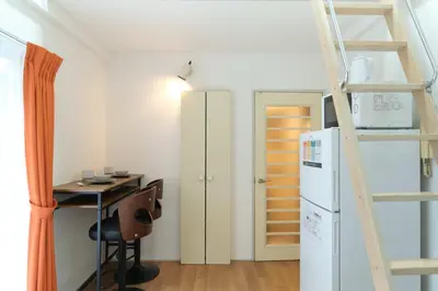 a room with a desk and a refrigerator and a ladder at Sakura Yoyogi by Tranova by Tranova in Tokyo