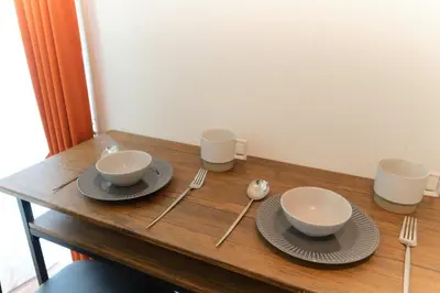 a wooden table with two bowls and plates and silverware at Sakura Yoyogi by Tranova by Tranova in Tokyo