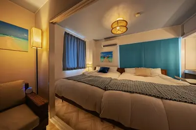 a bedroom with a large bed with a blue wall at LAGOON Suite OHANA in Tokyo