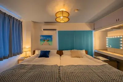 a bedroom with a large bed with blue walls at LAGOON Suite OHANA in Tokyo