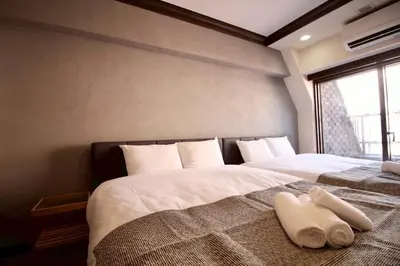 a bedroom with two beds with white sheets and a window at \u30b5\u30f3\u30e2\u30fc\u30eb\u30af\u30ec\u30b9\u30c8506 in Tokyo