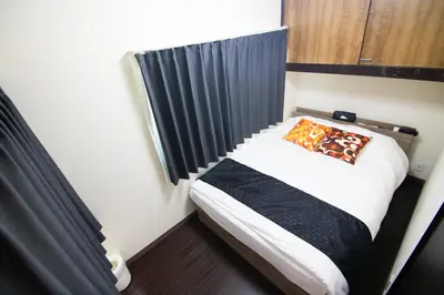 a small bed in a room with a black curtain at Omori Tei\u5927\u68ee\u4eadOMT 18min to Haneda, 3min Omori, Max 7 people in Tokyo