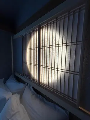 a window in a room with a bed in front of it at fukuhana \u6771\u65b0\u5bbf C3 in Tokyo