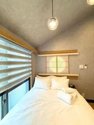 a bedroom with a large white bed with a window at fukuhana \u6771\u65b0\u5bbf C3 in Tokyo