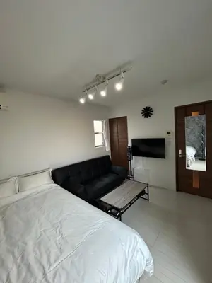 a living room with a bed and a couch at Park side stay Shinjuku in Tokyo