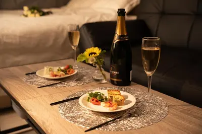 a table with two plates of food and a bottle of wine at Park side stay Shinjuku in Tokyo