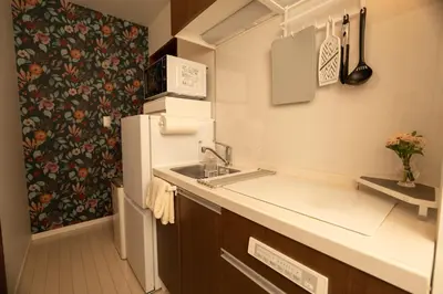 a small kitchen with a sink and a refrigerator at Park side stay Shinjuku in Tokyo