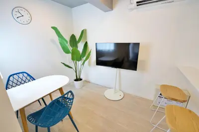 a living room with a table and chairs and a tv at Heureux\u690e\u540d\u753a 303 in Tokyo