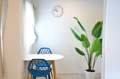 a table and two chairs and a clock on a wall at Heureux\u690e\u540d\u753a 303 in Tokyo