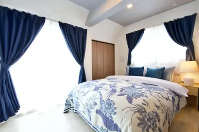 a bedroom with a blue and white bed and large windows at Heureux\u690e\u540d\u753a 303 in Tokyo