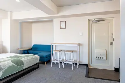 a bedroom with a bed and a blue couch at \u30a8\u30b9\u30dd\u30ef\u30fc\u30eb10f in Tokyo
