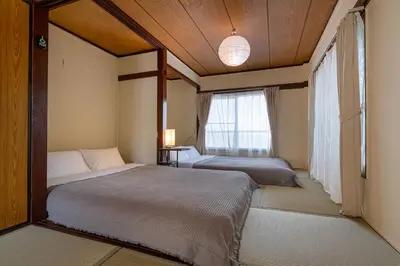two beds in a room with a window at \u65e7U\u90b82f3f in Tokyo