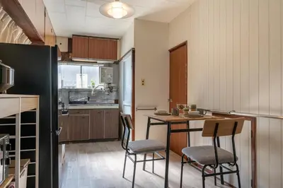 a kitchen with a table and chairs in a room at \u65e7U\u90b82f3f in Tokyo
