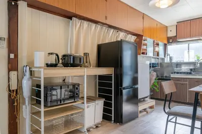a kitchen with a black refrigerator and a table at \u65e7U\u90b82f3f in Tokyo