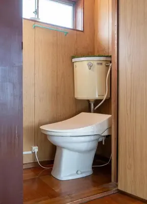 a bathroom with a toilet in a wooden wall at \u65e7U\u90b82f3f in Tokyo