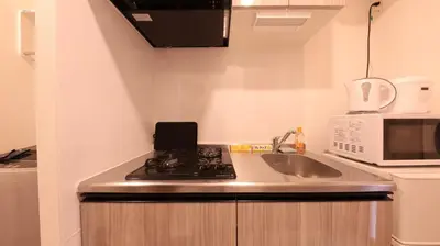 a small kitchen with a sink and a microwave at \u3089\u3057\u3063\u304f\u3059\u6c60\u888b204 in Tokyo