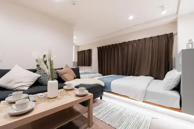 a living room with a bed and a couch at Shinjuku SAIEI Hotel 301 in Tokyo