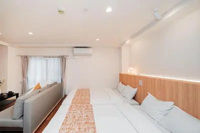 a room with a bed and a couch and a window at Shinjuku SAIEI Hotel 302 in Tokyo
