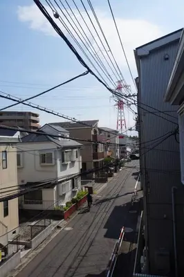 an empty street with buildings and a red crane at D Regalo in Ichikawa