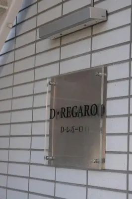 a sign on the side of a brick wall at D Regalo in Ichikawa