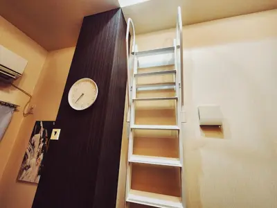 a staircase in a room with a clock on the wall at The Hotel REPOS SUMIDA2 in Tokyo