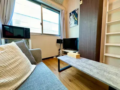 a living room with a couch and a table at The Hotel REPOS SUMIDA2 in Tokyo