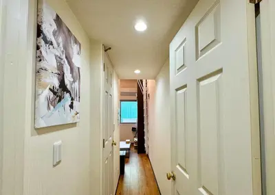 a hallway with a white door and a room with a table at The Hotel REPOS SUMIDA2 in Tokyo