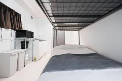a bedroom with a bed in a white room at Shinjuku SAIEI Hotel 202 in Tokyo