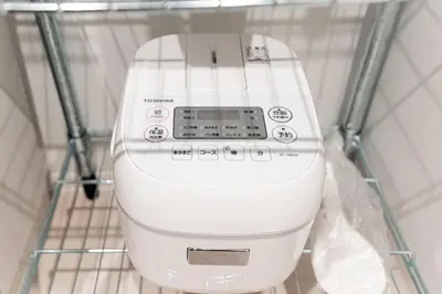 a white washing machine sitting in a rack at Shinjuku SAIEI Hotel 202 in Tokyo