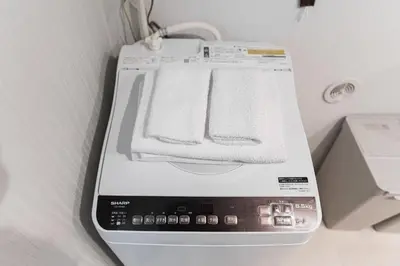 a washing machine with two towels on top of it at Shinjuku SAIEI Hotel 202 in Tokyo