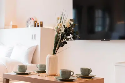 a table with three cups and a vase with flowers at Shinjuku SAIEI Hotel 401 in Tokyo