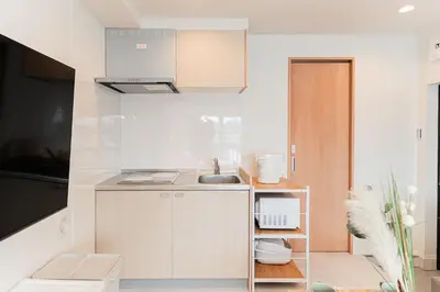 a small kitchen with white cabinets and a sink at Shinjuku SAIEI Hotel 401 in Tokyo
